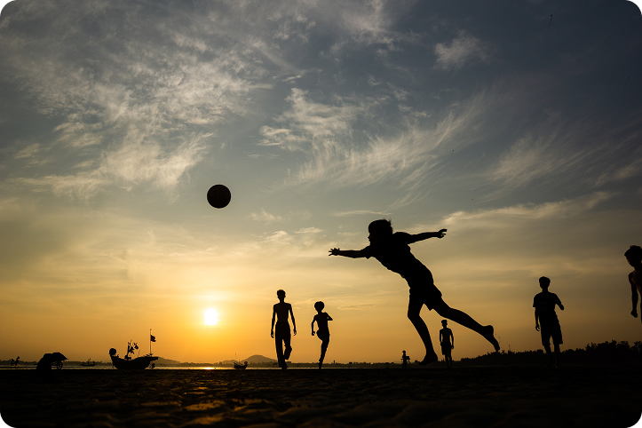 Atletas comemorando ao entardecer no campo
