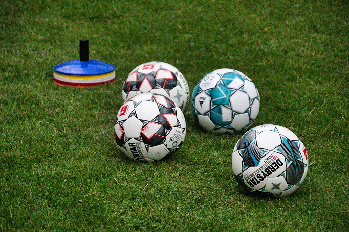 Bolas de treino enfileiradas no gramado